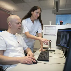 To sykehusansatte ser på radiologibilder på skjerm