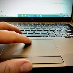 En hånd som holder en bærbar datamaskin