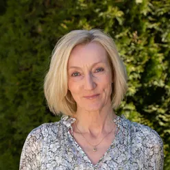 Smilende kvinne med blondt hår. Foto.