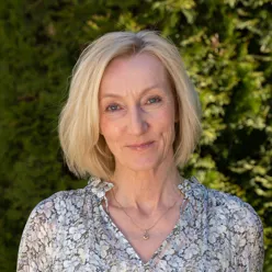 Kvinne med halvlangt blondt hår som smiler. Foto.